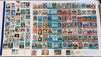 Grid layout of about 70 assorted baseball and football cards mostly football in nature shown on a white surface