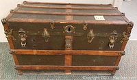 Front view showing wood slats, dark canvas panels and brass hardware