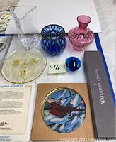 Group photo of Simon Pearce vase, blue and pink vases, footed glass tray, blue mushroom paperweight and Songbirds of America glass art plaque