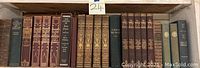 Wide shot showing multiple vintage hardcover books including history and classics on a shelf.