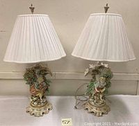 Pair of lamps on table showing both boy and girl figural bases with shades