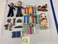 Photo showing the collection of vintage sailor dolls, many PEZ dispensers, and various small figurines as well as a dog head figurine and a Popeye car toy with characters.