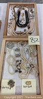 Wooden tray holding multiple necklaces and jewelry items