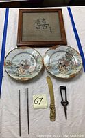 Full lot showing framed calligraphy art, two decorative plates, brass letter opener, silverplate chopsticks, and bonsai clipper tool.