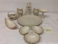 Full view of the Lenox porcelain lot with all items arranged on a white surface. Includes figurines, divided platter, basket, candle holders, comport, and nut/candy dish.