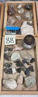 Top view of the entire wooden tray with mineral rock specimens spread out, showing the variety of shapes, colors, and textures.