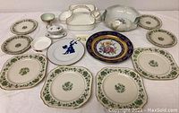 Full display of various china pieces arranged on a surface showing plates, serving dishes, and decorative items.