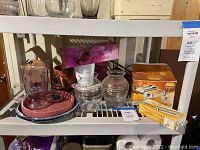 Photo showing the pasta maker in original box along with various glass vases, pots and containers on a shelf.