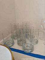 Group of nine glasses including low bar glasses and taller ones with original stickers visible.