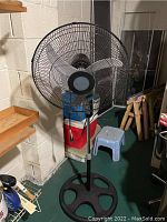 Full view of larger Holmes standing fan showing the base, stand, and fan head mounted on the stand.