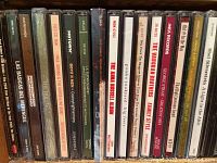 Photo showing a row of assorted music CD cases with various artists and albums.