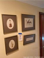 Group photo of all four framed cross stitch musical instrument artworks hanging on a wall, showing sizes and frame styles.