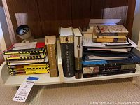 Shows collection of Shakespeare Cliff Notes and hardcover books arranged on a white rack including multiple Cliff Notes and hardcover titles