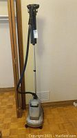 Full view of Conair rolling clothes steamer standing upright, showing telescoping pole, steam head, and base on wheels.
