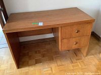 Full view of oak desk showing the top, side panel, and the two drawers on the right side.