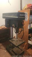 Front-left angle view of drill press showing head, column, table and base
