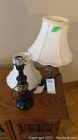 Photo showing both lamps with shades, displaying overall condition and appearance on wooden surface.