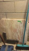 Two marble slabs leaning against a wall, showing pink and white marbled pattern and smooth edges.