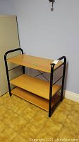 Front view of the 3 tier MDF shelf with black metal sides and frame.