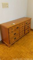 Full view of the solid wood dresser showing its shape, finish, and drawer configuration