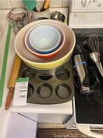 Overview of nested Pyrex bowls, muffin tins, rolling pin, and hand blender