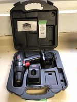 Full view of the open case including the Jobmate cordless drill, battery charger, and instruction manual inside the molded hard plastic case.