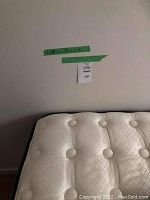 Top of mattress showing tufted surface and partial box spring underneath