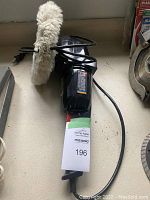 Full view of sander polisher showing attached cloth buffing wheel and power cord.