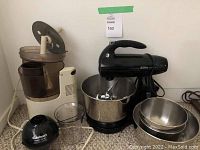 Photo showing Sunbeam stand mixer, Cuisinart food processor, metal bowls, and measuring cup.