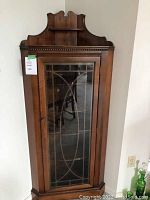 Front closed view showing leaded glass door and dentil molding across top apron