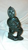Front view of the Inuit soapstone carving depicting mother holding child in traditional clothing.