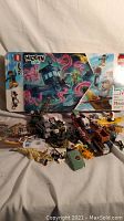 Photo showing Lego Hidden Side 70419 set with kayaker, crocodile, fisherman minifigures, boat, various pieces, and original box in background.