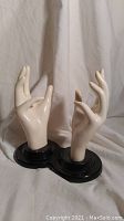 Front and side view of the pair of mannequin hands on black base showing overall shape and size