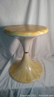Full view of the MCM vintage tulip stool showing marbled yellow and white plastic material with a tulip shape base and seat.