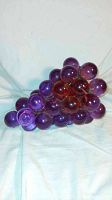 Photo showing cluster of translucent light purple lucite grape spheres assembled on a conical metal frame.