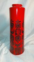 Front and side views of the tall red ceramic vase showing black floral pattern and glossy finish.