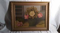 Full view of framed oil painting showing roses in vase on table with wood gold finish frame.