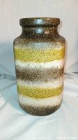 Front angled view of vintage West Germany vase showing layered earth-tone stripes and textured finish