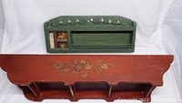 Top view of both wooden pieces showing the green spice rack with spice jars and the reddish-brown shelf with floral painting.