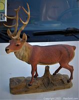 Front and side view of the carved wood stag statue showing detailed antlers and painted body on carved base.