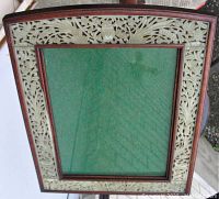 Top-down angled view showing the curved profile of the rosewood frame and detailed carved jade border with floral and bird designs.