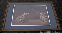 Full view of the framed print showing two Indigenous Native dancers wearing raven masks set in a wood frame with blue mat.