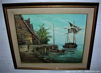 Framed oil painting showing a harbour scene with boats and a stone building, signed by A Harris in the bottom right corner.