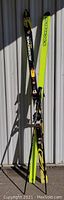 Pair of Rossignol Racing Kevlar skis with bindings, yellow base and black top surface with brand markings.