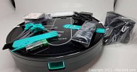 Photo showing Deenkee robotic vacuum cleaner with remote control, power adapter, cleaning brushes and accessories on top