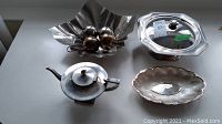 Photo showing all items including stainless steel bowl with decorative orbs, silver plate platter, and stainless steel teapot