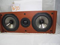 Front view of the Boston Acoustics CS225C speaker showing two silver cone woofers and a central black tweeter in a wooden cabinet