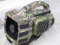 Close-up of the camouflaged Primos Dogg Trap electronic predator call showing the speaker horn, handle, and keypad.