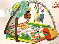 Bright Starts Winnie the Pooh colorful play mat with attached soft arch toy bars including hanging Tigger plush, bee, and mirror toy.