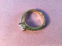 Swarovski ring showing round central crystal and side pavé crystals on rose-gold tone band.